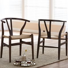 two wooden chairs sitting next to each other on top of a rug