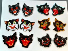 a bunch of cat magnets that are on top of a white board with black and red cats