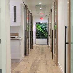 an empty hallway with wooden floors and white walls