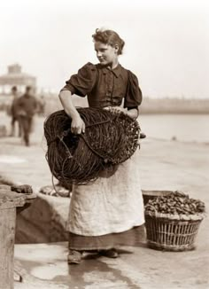 an old black and white photo of a woman with baskets