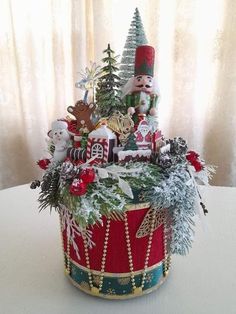 a basket filled with christmas decorations on top of a white table next to a window