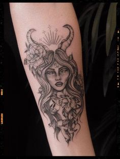 a woman with horns and flowers on her arm