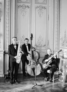 three men in tuxedos are playing instruments