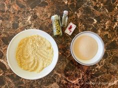 two bowls filled with food sitting on top of a counter next to bottles and containers