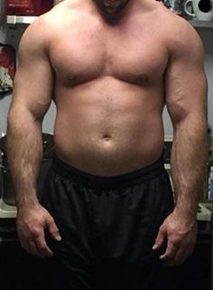 a shirtless man standing in front of a kitchen counter top with his hands on his hips