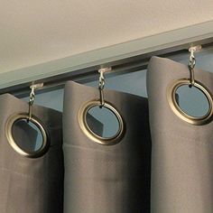 curtains with rings hanging from them in front of a window