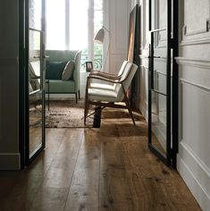 a chair sitting in the middle of a living room next to a doorway with glass doors