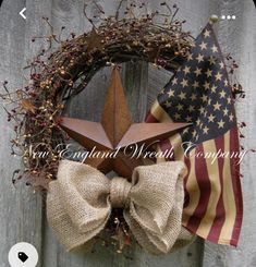 a wreath with an american flag and a star hanging on the side of a wooden fence