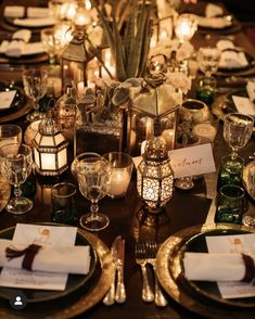 the table is set with candles, plates and place settings for an elegant dinner party