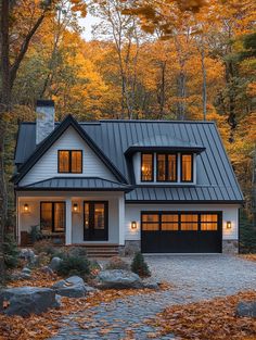 a house in the woods with lots of trees and leaves on the ground around it