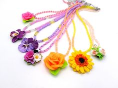 Embrace the unique charm of these exquisite, handcrafted polymer clay flower pendant necklaces. Carefully sculpted to bring the beauty of nature's blossoms to your wardrobe, each necklace is a wearable work of art. Vibrant colors and intricate details make every piece one-of-a-kind, perfect for those who love to stand out with their accessory choices. Whether you're dressing up for a special occasion or adding a touch of floral elegance to your everyday look, these necklaces are sure to enchant. Whimsical Multicolor Flower Shaped Jewelry, Whimsical Polymer Clay Flower Jewelry, Multicolor Flower-shaped Jewelry With 3d Flowers, Whimsical Flower-shaped Polymer Clay Jewelry, Multicolor 3d Flower Shaped Jewelry, Whimsical Flower Necklace For Gifts, Whimsical Multicolor Flower Necklace, Multicolor Flower Pendant Necklace, Multicolor Flower Necklace For Gift