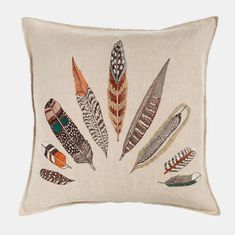 an embroidered pillow with feathers on it