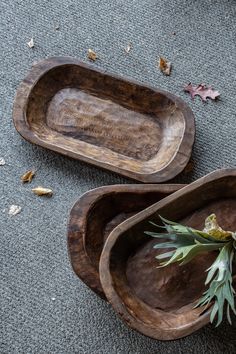 two wooden trays sitting on top of a carpeted floor next to each other