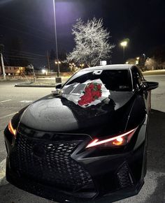 a car parked on the side of the road at night with its hood covered in flowers