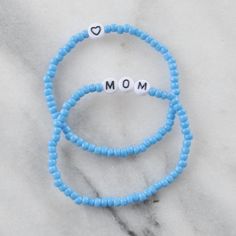 Looking for the perfect gift for your mom this Mother's Day? Look no further than our MOM stretch bracelet set in vibrant, playful colors! It's a fun and unique way to show your appreciation to the most important woman in your life. SOLD IN A SET OF 2: one says "MOM", one has a heart 2-3mm chunky glass beads with flat white letter beads available in 6.5" one-size-fits-most (custom sizing not available at this time) strung on stretch cords for easy on and off style comes in 3 fun colors: choose Sky, Sunshine, or Bubblegum packaged in a clear resealing bag for storage and gift giving to keep your jewelry looking new, avoid water, lotions and perfumes Playful Beaded Bracelets For Mother's Day Gift, Casual Letter Beads Stretch Bracelet For Mother's Day, Playful Beaded Jewelry For Mother's Day, Casual Everyday Bracelets For Mother's Day, Blue Name Bracelet For Mother's Day Gift, Casual Mother's Day Bracelets With Letter Beads, Casual Letter Beads Bracelets For Mother's Day, Casual Stretch Bracelet With Round Beads For Mother's Day, Fun Blue Bracelets For Gifts