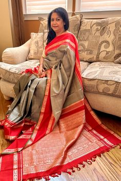 Expertly handcrafted with traditional korvai technique, the Kanjivaram Silk Saree boasts a luxurious sage grey body and stunning red border and pallu. With intricate grand threadwork, this saree exudes elegance and sophistication. Elevate your wardrobe with this timeless and exquisite piece of Indian heritage. The blouse piece is elegantly hand embroidered to match the saree. Approximate Length 6.5 mtrs (inclusive of blouse length) Approximate Height - 46 - 48" Approximate weight - 1.5 lbs Saree comes with fall, picot and tassels done when applicable. Blouse piece is cut. Kindly Note : The colors you see on your device may vary due to the color reproduction, brightness and resolution of individual devices. If you'd like more clarity before your purchase, please contact our support team. Red Saree With Zari Weaving, Festive Tussar Silk Pre-draped Saree With Weaving Work, Red Tussar Silk Pre-draped Saree With Motifs, Red Slub Silk Pre-draped Saree With Zari Weaving, Festive Red Tussar Silk Pre-draped Saree, Red Saree, Silk Cotton Sarees, Indian Heritage, Blouse Length