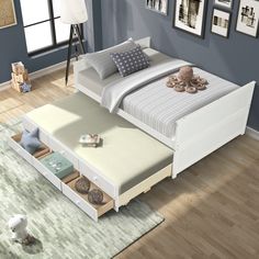 a white bed sitting on top of a hard wood floor next to a blue wall