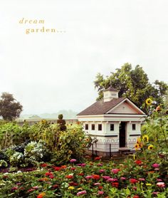 there is a small white house in the middle of some flowers and trees with words above it