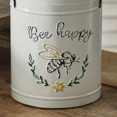 a bee happy canister sitting on top of a wooden table