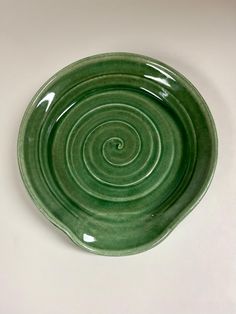 a green plate sitting on top of a white table