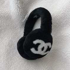 a pair of black and white ear muffs laying on top of a white blanket