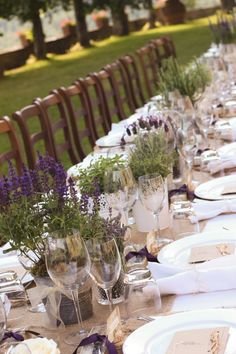 a long table is set with place settings and flowers