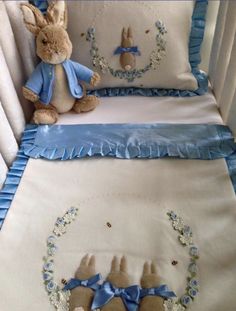 a baby crib with two stuffed animals on it's sides and blue trimmings