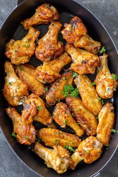 chicken wings in a skillet with parsley