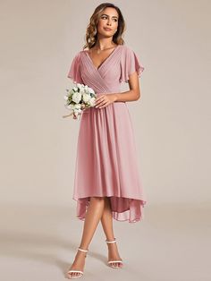 a bridesmaid in a pink dress holding a white bouquet and posing for the camera