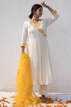 Ivory and yellow silk chanderi angrakha anarkali with resham thread embroidered neckline and cuffs. Comes with pant and a pure organza dupatta.
Components: 3
Pattern: Embroidered
Type Of Work: Resham thread
Neckline: V Neck
Sleeve Type: Three quarter
Fabric: Malai chanderi, Dupatta : Pure organza, Lining : Fine Mulmul
Color: Ivory
Other Details: 
Closure : Tie-up with tassels
Disclaimer : The natural imperfection and textures in the weaves are the outcome of handloom fabrics (not to be considere Anarkali Style Bandhgala With Resham Embroidery, Fitted Cotton Silk Anarkali Set With Gota Work, White Long Bandhgala With Dupatta, Anarkali Bandhgala With Traditional Chanderi Drape, Fitted Off White Salwar Kameez With Zari Work, Festive Off White Fitted Anarkali Set, Fitted Off-white Salwar Kameez With Cutdana, White Long Dupatta With Pallu, Fitted Off White Kurta With Cutdana