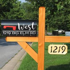 a mailbox sitting on the side of a road next to a wooden post with a sign that says west 1219 big elm rd