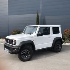 a white jeep parked in front of a building