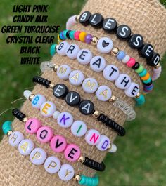 a stack of bracelets with the words breathe and love spelled on them in different colors