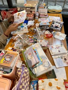 the table is covered with many items for making cards and crafts, including envelopes