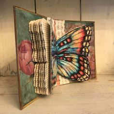 an open book with a butterfly painted on it