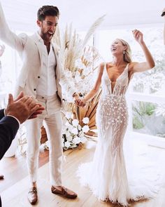 a bride and groom are dancing together in the living room