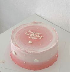 a pink cake with white frosting and stars on it