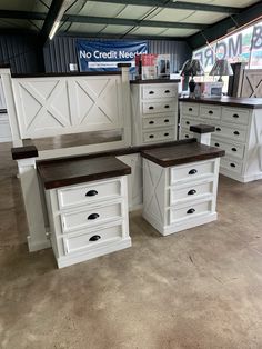 several white dressers with wooden tops in a warehouse