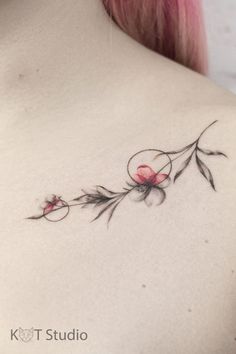 the back of a woman's shoulder with flowers and leaves tattooed on her chest