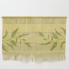 a green and beige wall hanging with leaves on it