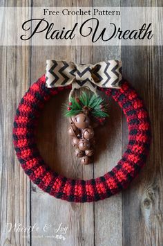 a crocheted wreath with pine cones and bells on it, sitting on a wooden surface