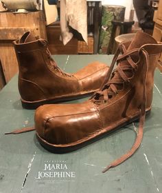 a pair of brown boots sitting on top of a table