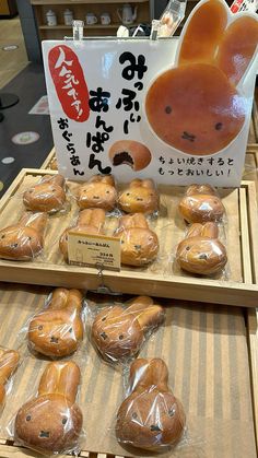 there are many breads on display in the store for sale, and one has an image of a teddy bear