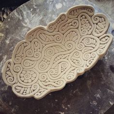 a bowl that is sitting on top of a stone slab in the process of being carved