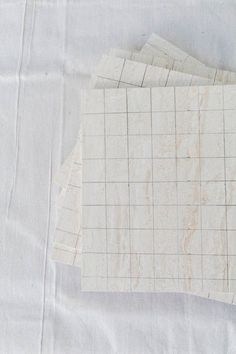 four pieces of white marble sitting on top of a sheet of paper next to each other