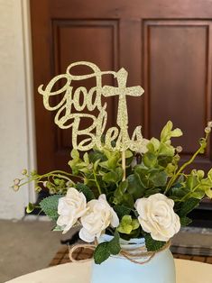 a vase filled with flowers and a cake topper that says god's be