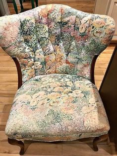 an old chair with floral fabric on it