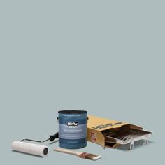 a paint can and brush sitting next to a cardboard box on a blue background,