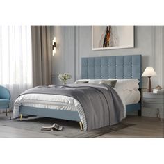 a bed with blue upholstered headboard and foot board in a bedroom setting