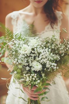 a woman holding a bouquet of white flowers